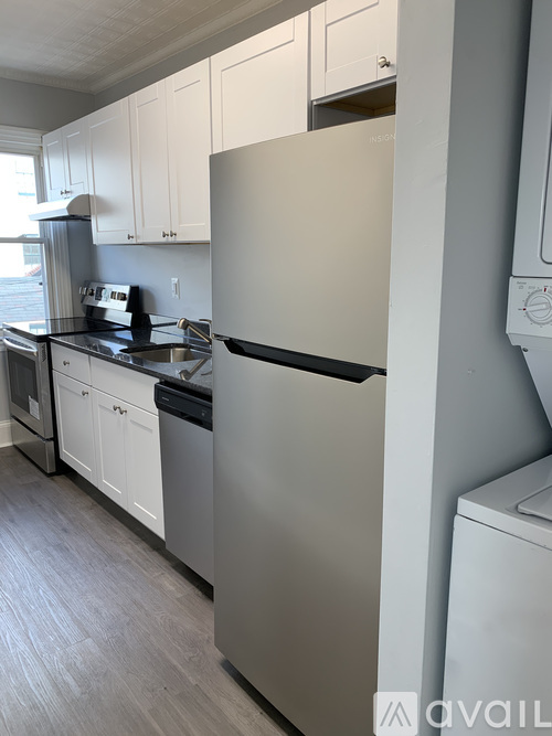 A kitchen with a white fridge and cabinets.