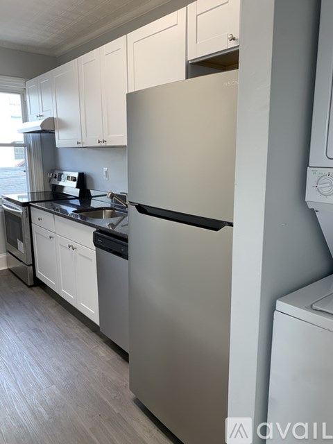 A kitchen with a white fridge and cabinets.
