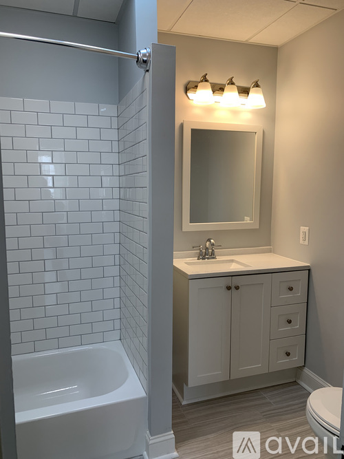A bathroom with a white tub and sink.