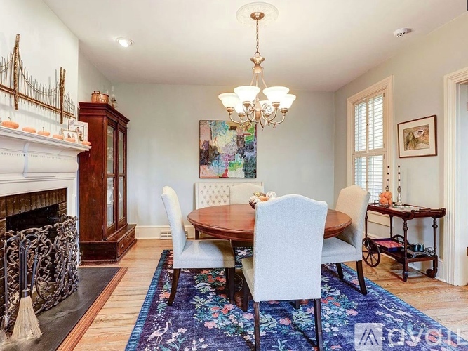 A dining room with a wooden table and chairs.