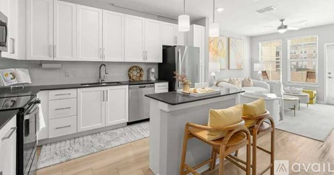 A kitchen with white cabinets and a black countertop.