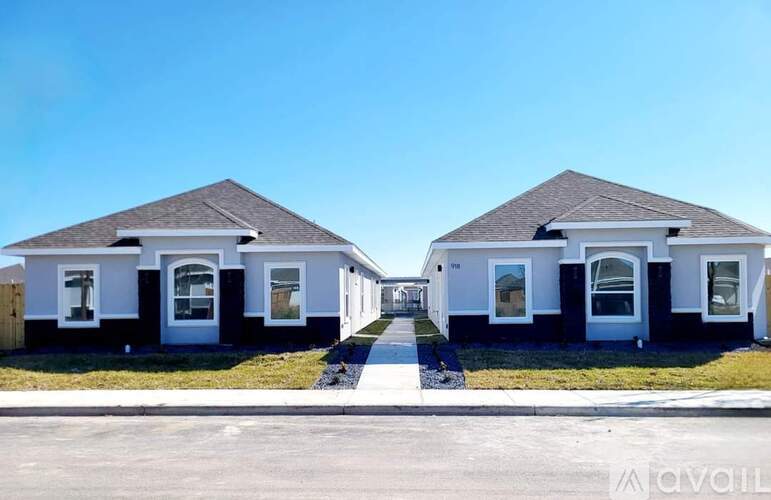 Two identical houses are shown with a clear blue sky in the background.