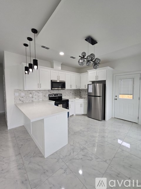 A kitchen with white cabinets and a marble countertop.