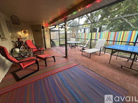 A patio with a red chair and a blue table.