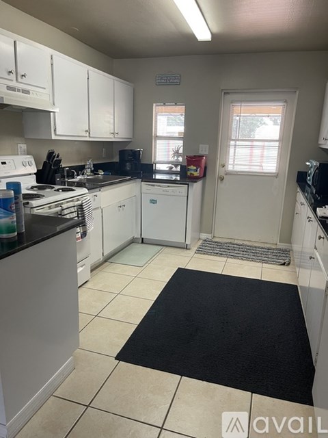 A kitchen with white cabinets and appliances.