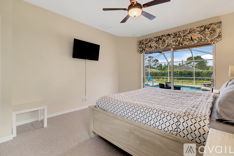 A bedroom with a large bed and a flat screen TV mounted on the wall.