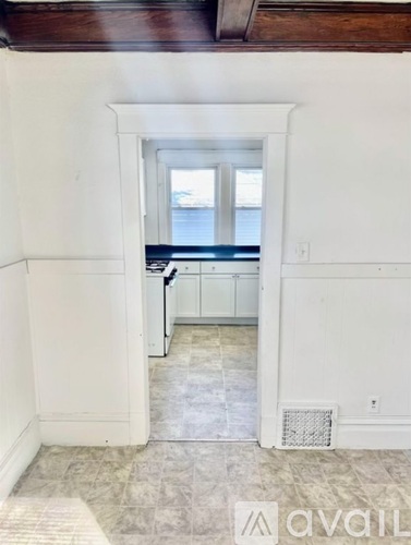 A room with a window and a washing machine.