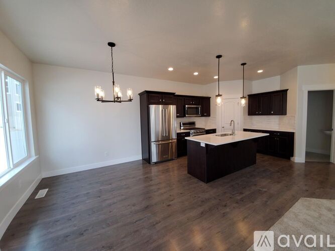 A modern kitchen with dark wood floors and a central island.