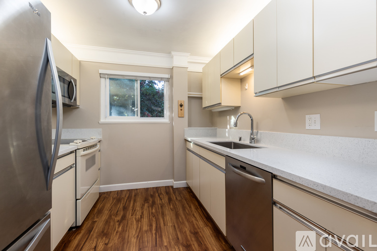 A kitchen with a stainless steel refrigerator and wooden floors.