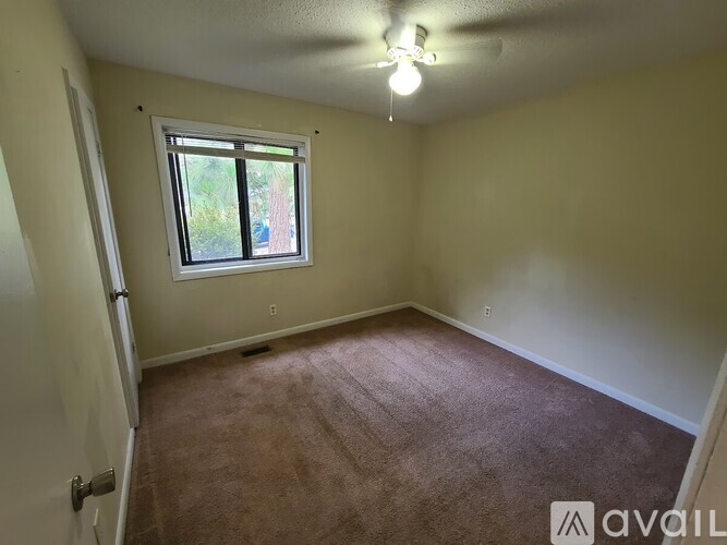 A room with a carpeted floor and a window.