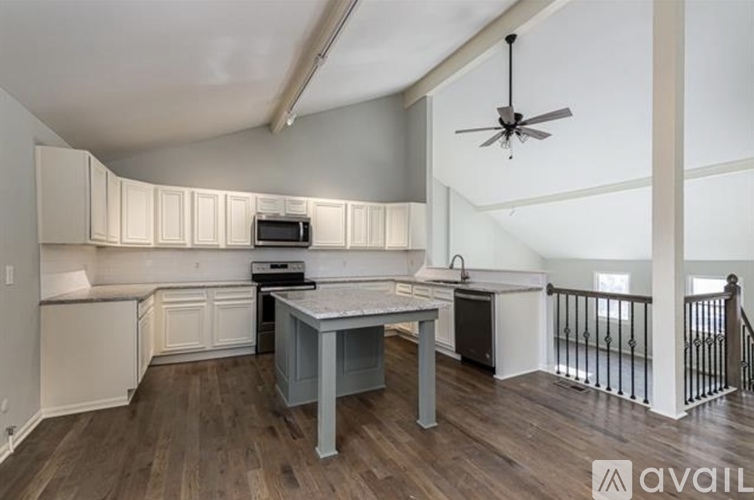 A kitchen with a table and chairs and a fan.