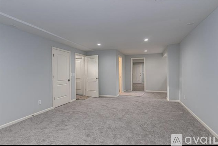 A spacious room with carpeted floor and white walls.
