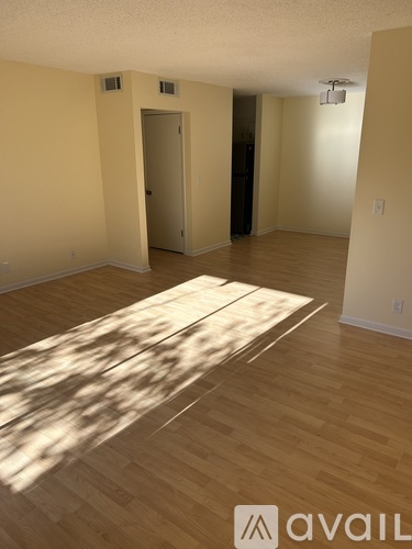 A room with wooden floors and a rug in the middle.