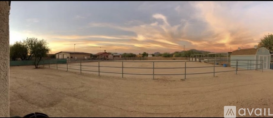 A fenced area with a cloudy sky above.