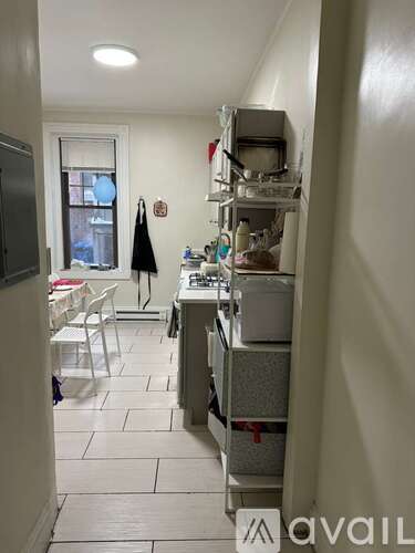 A kitchen with white cabinets and a window.