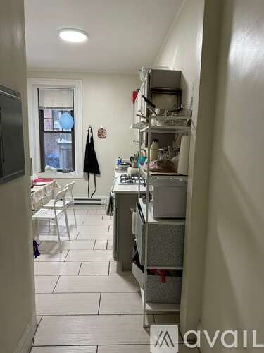 A kitchen with white cabinets and a window.