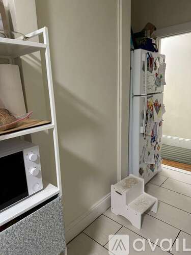 A white fridge with many magnets on it in a kitchen.