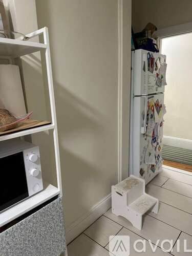 A white fridge with many magnets on it in a kitchen.