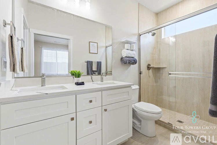 A bathroom with a toilet, sink, and mirror.