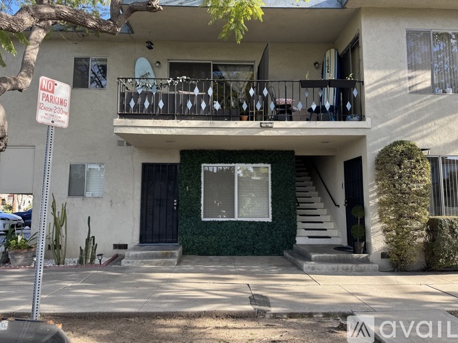 A two-story house with a balcony and a sign that says "NO PARKING".
