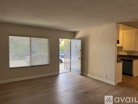 A room with a sliding glass door and a kitchen area with a counter and cabinets.