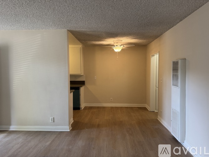 A room with wooden floors and a ceiling fan.