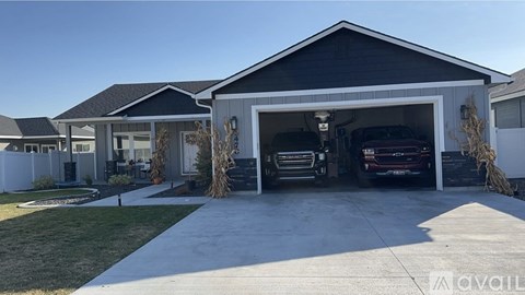 A modern house with a garage and a car inside.