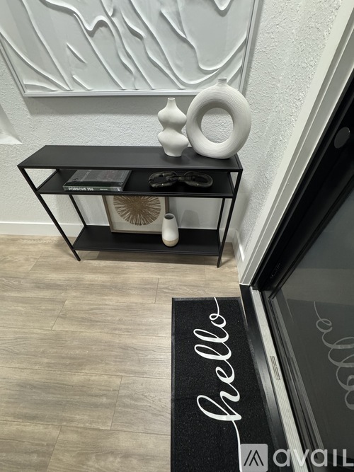 A black and white photo of a shelf with a vase on it.