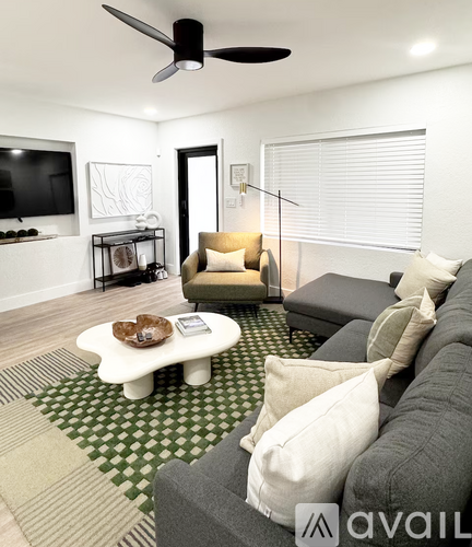 A living room with a grey couch and a white coffee table.