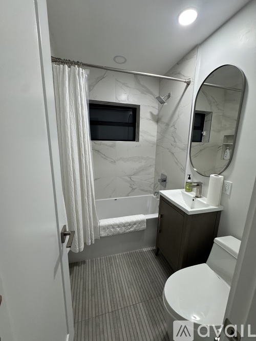 A bathroom with a toilet, sink, and shower.