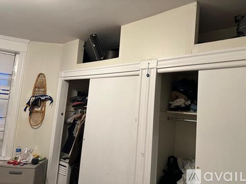 A white closet with a mirror and a shoe rack.