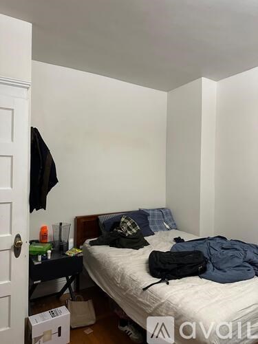 A bedroom with a bed, a desk, and a door.