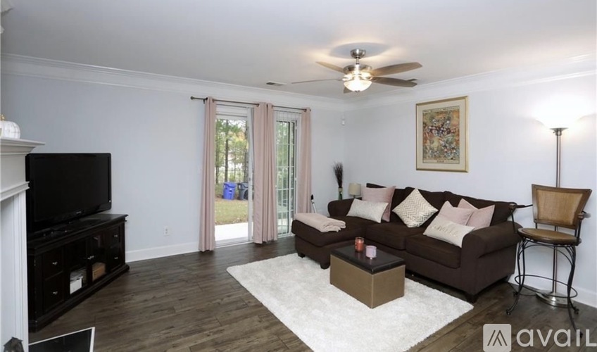 A living room with a brown couch, a television, and a fireplace.