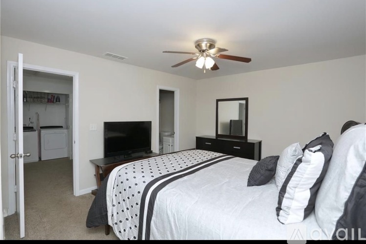 A bedroom with a bed, dresser, and television.