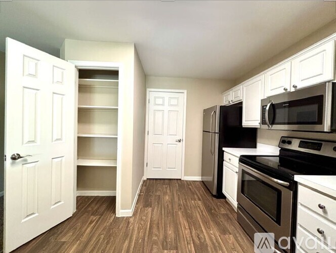 A kitchen with white cabinets and black appliances.