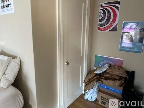 A room with a door, a pillow, and a box on the floor.