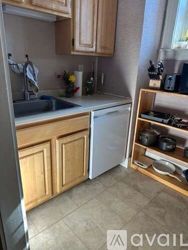 A kitchen with wooden cabinets and a white dishwasher.