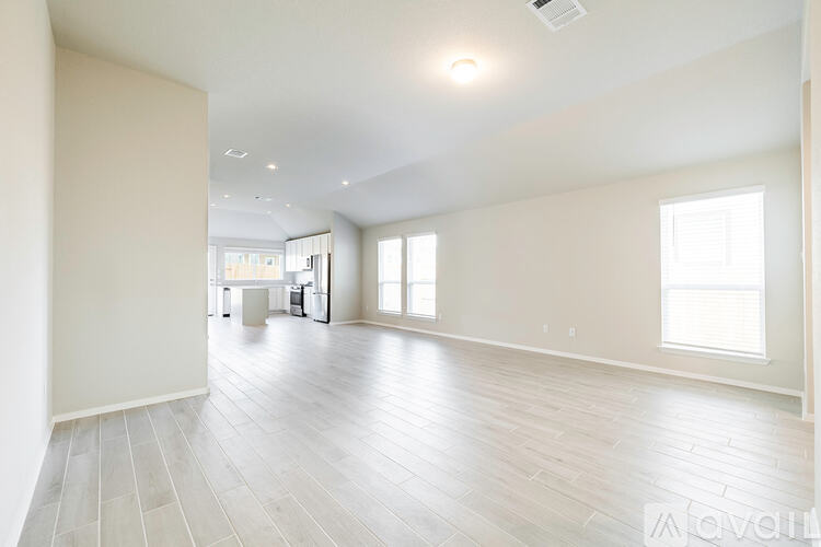 A spacious room with white walls and a large window.