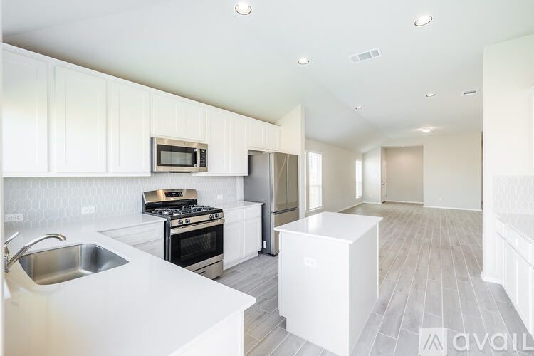 A modern kitchen with white cabinets and a stainless steel sink.