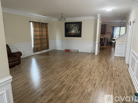 A living room with wood flooring and a painting on the wall.