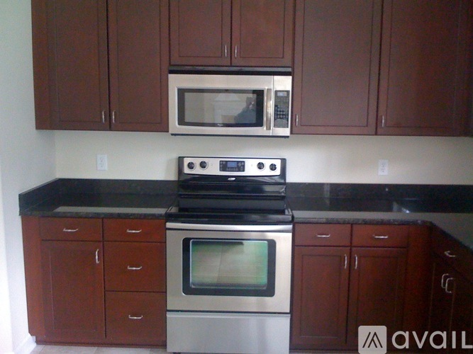 A kitchen with brown cabinets and a black countertop.