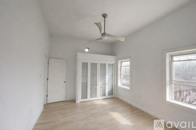 A room with a fan, a window, and a door.