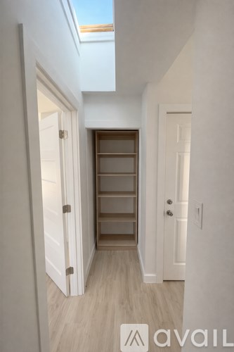 A hallway with a skylight and a door on the right.