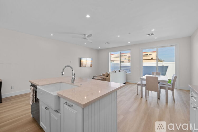 A kitchen with a marble countertop and a dining table with chairs.