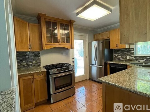 A kitchen with wooden cabinets and a granite countertop.