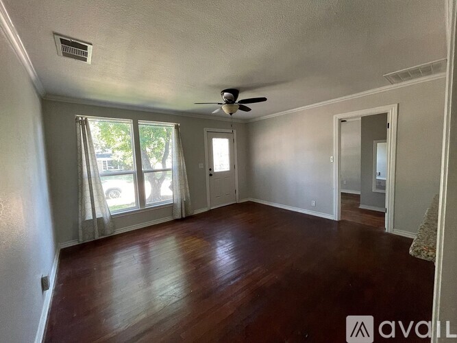 A room with wooden floors and a ceiling fan.