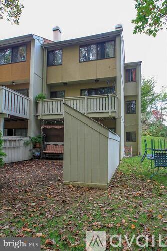 A beige and brown apartment building with a balcony and a deck.