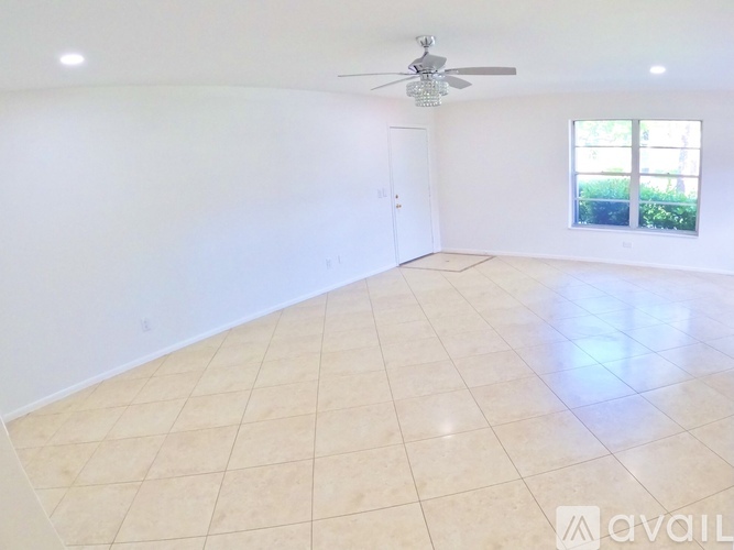 A spacious room with a ceiling fan and a window.