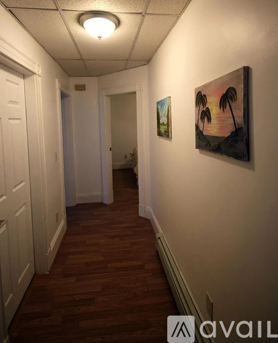 A hallway with a painting of palm trees on the wall.