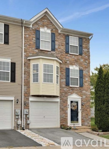 A two-story house with a garage and a stone facade.